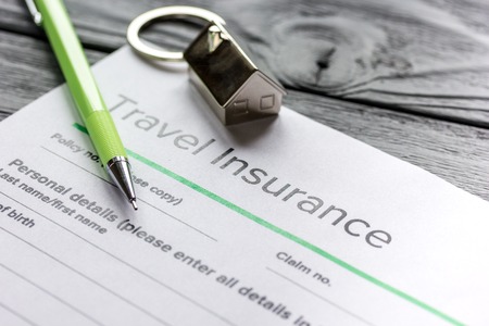 Traveling concept with insurance application form on gray wooden table backgroundの写真素材