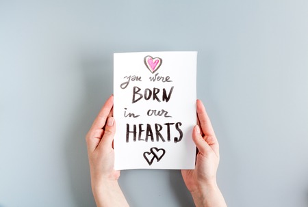 happy family concept with card and hands on gray desk background top view mock upの写真素材