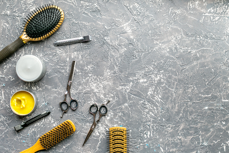 styling hair with hairdressing tools in barbershop concept on gray table background top view mock-upの写真素材