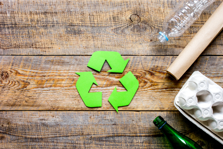 recycling symbol with waste on wooden background top view mockupの写真素材