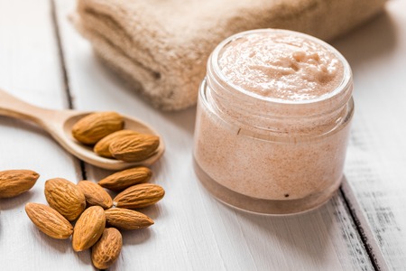 Natural scrub with almonds extract and towel on light table backgroundの写真素材