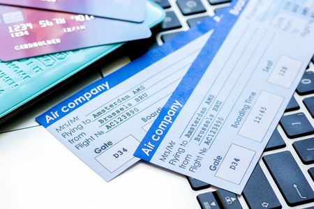 travel concept with credit cards, copybook and flight tickets on laptop keyboard backgroundの写真素材