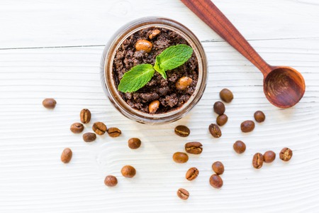 Homemade cosmetics with organic coffee scrub and mint on white desk background top viewの写真素材