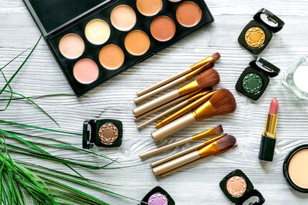 decorative cosmetic set with eye shadow palette and brushes on light woman table background top viewの写真素材