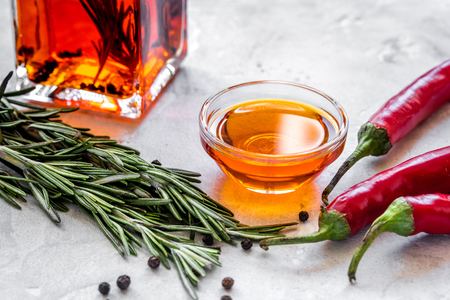 jar with oil and chili on stone table backgroundの写真素材