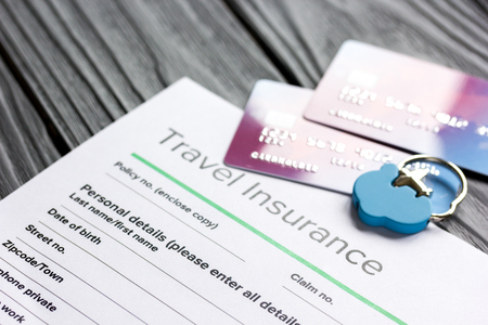 Travel preparation concept with insurance and cards on wooden table
