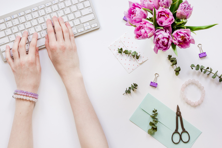 Woman office desk with flowers on white background top viewの写真素材