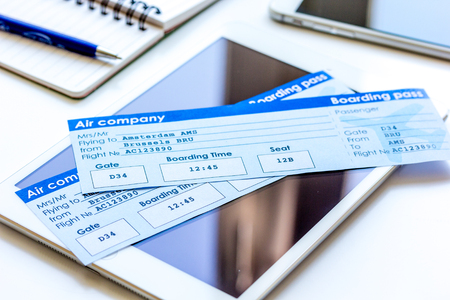 Credit cards with airline tickets and tablet for vacations on white table backgroundの写真素材