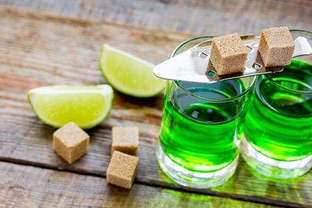 Absinthe in glass with lime slices on wooden backgroundの写真素材