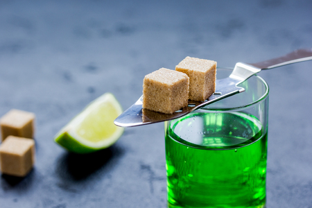 Absinthe shots with lime slices and sugar on dark table backgroundの写真素材