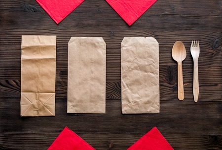 food delivery with paper bags and flatware wooden background top view mockupの写真素材