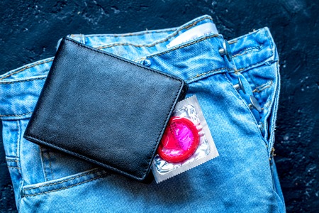 concept male contraception condom in jeans pocket top viewの写真素材