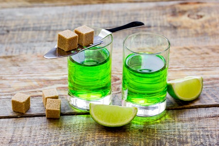 green shots with sugar and lime on table background