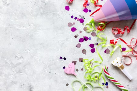 Colored party hat, sweets and confetti on stone table background top view mockupの写真素材