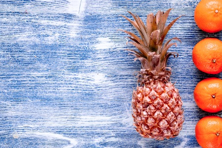 pineapple and oranges on blue desk background top view space for textの写真素材