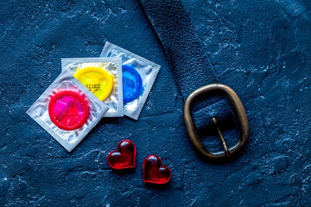 concept safe sex with condom on dark background top view