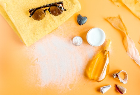cream and lotion cosmetic for sun protection orange background top view mock-upの写真素材