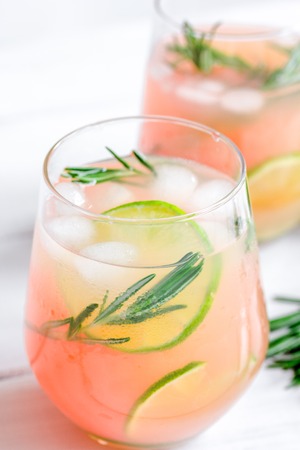 fitness cocktail in glass with lime and rosemary on white table backgroundの写真素材