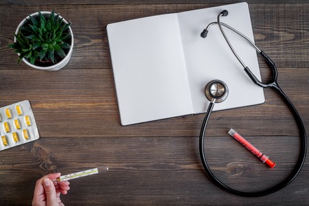 children's doctor work with stethoscope and opened notebook on wooden desk background top view space for textの写真素材