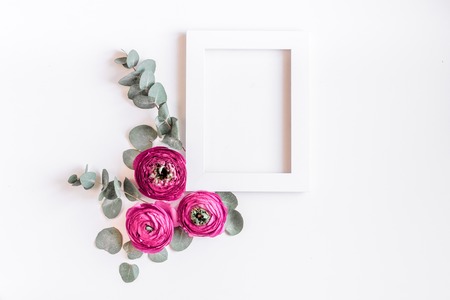 Trendy design with ranunculus flower on white desk background top view mock upの写真素材