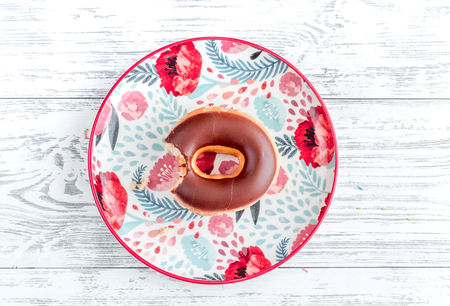 coloful donut with topping on plate flat lay on wooden background top view mock upの写真素材