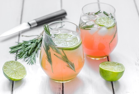 healthy morning fresh drink, knife, lime and rosemary on wooden table backgroundの写真素材