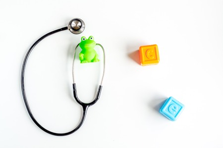 stethoscope, toys on childrens doctor office desk background top view mockupの写真素材