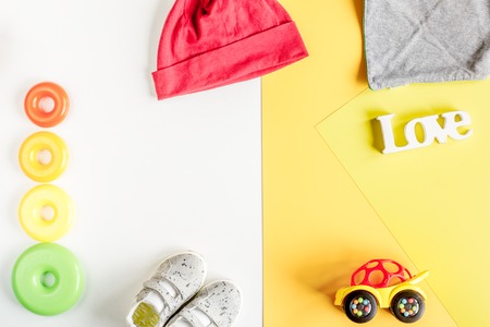Baby clothes and toys on white background top view mock up