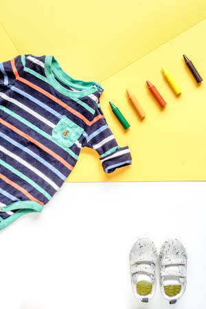 children flat lay with clothes yellow background top view space for textの写真素材