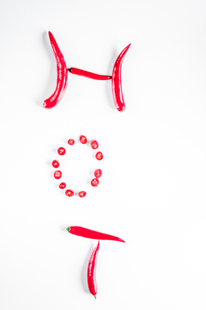 spicy food cooking with red chili pepper hot text on white table background top viewの写真素材