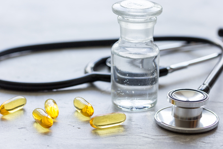 doctor's instruments and pills in medical set on white dest backgroundの写真素材