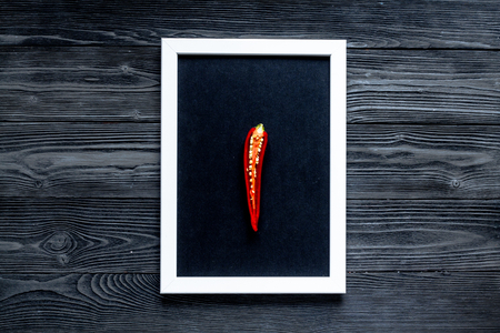 spicy food cooking with red chili pepper frame on dark wooden table background top viewの写真素材