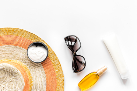 Summer cosmetic with protection cream and hat white background top view mock upの写真素材