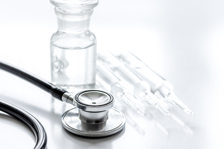 Doctor's instruments and vials in medical set on white dest backgroundの写真素材