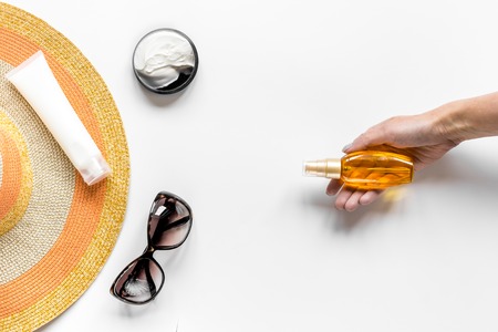Sun glasses, protiction cream, hat for beach rest white background top view mock-upの写真素材