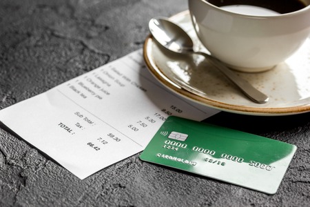 restaurant bill, credit card and coffee on dark table backgroundの写真素材
