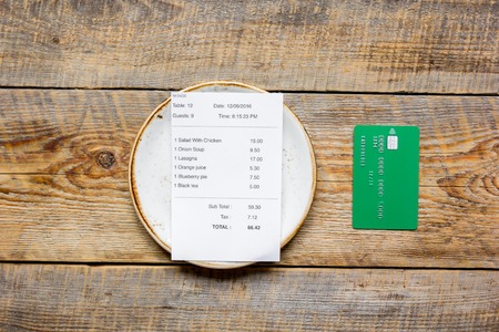 paying check for lunch in cafe with credit card on wooden table background top viewの写真素材