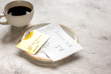 restaurant bill, credit card and coffee on stone table background