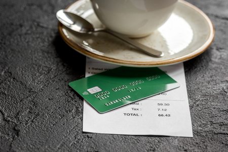 credit card for paying, coffee and check on cafe stone desk backgroundの写真素材