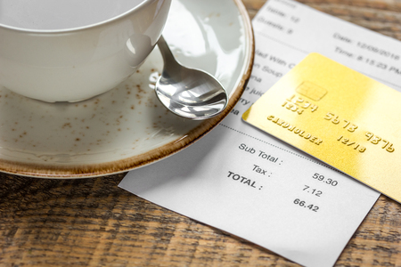 coffee and receipt bill for payment by credit card on wooden table backgroundの写真素材