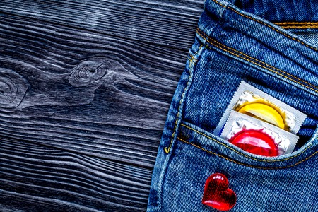 concept male contraception condom in jeans pocketの写真素材