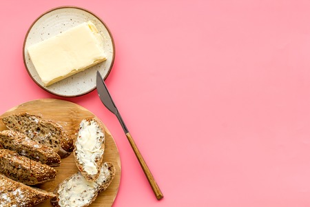 Slice of bread with butter on pink background top view copy spaceの写真素材