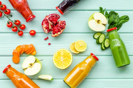 vegetable and fruit juice in bottles for diet drink on green wooden background top view mock upの写真素材