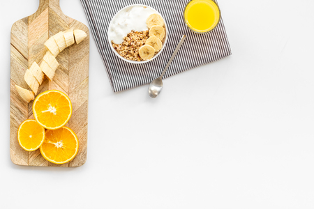 Healthy granola and orange juice for colorful breakfast on white background top view mock-upの写真素材