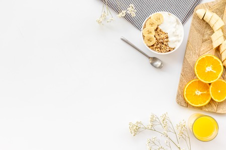 Bright breakfast with granola and orange juice on white  top view mockupの写真素材