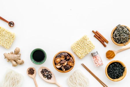 Chinese and Japanese food cooking with ginger, spices and noodles on white background top view mockupの写真素材