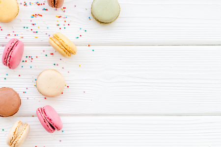 sweet dessert pattern with macarons on white wooden background flat lay mockupの写真素材