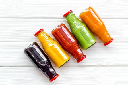 vegetable and fruit juice in bottles for diet drink on white wooden table background top view mock upの写真素材