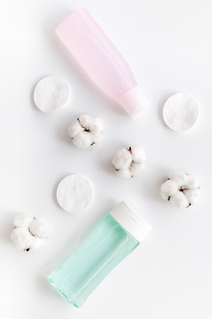 facial tonic, lotion and cotton pads for face care on white background top view mock upの写真素材