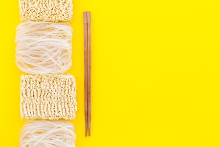 Rice vermicelli, noodles, sticks to cook Chinese and Japanese food design on yellow background top view copy spaceの写真素材